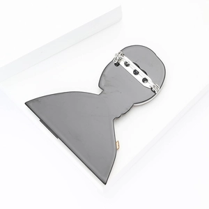 Close-up of a minimalist black acrylic cat girl brooch pin with a polished finish