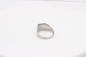 Close-up of a silver signet ring with a flat square surface made of polished titanium steel