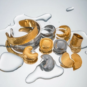 Macro shot of 18k gold fish scale pattern jewelry set with water droplet reflections