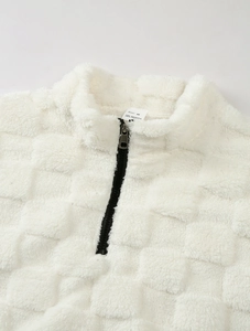 Détail d'un sweat à capuche en polaire blanche avec demi-zip et texture gaufrée