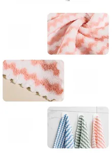 Close-up of coral fleece cleaning cloth with pink wave pattern and durable edge stitching