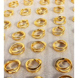 Golden irregular double-layer crossover rings arranged on a shimmering silver background
