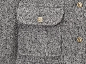 Détail du tissu polaire gris avec bouton décoratif en métal doré gaufré