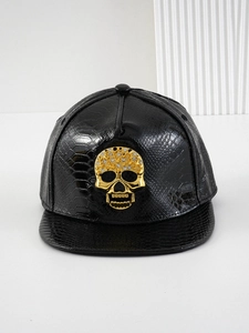 Close-up of black snake texture leather baseball cap with golden skull and rhinestones
