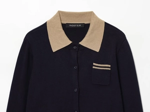 Detail of color-block knit polo shirt featuring a khaki collar and navy blue chest pocket