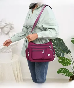 Dettaglio borsa a tracolla in nylon viola con tasche multiple e ampia capacità