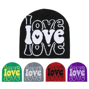 Detail view of the LOVE letter jacquard knit pattern on winter beanies in five colors