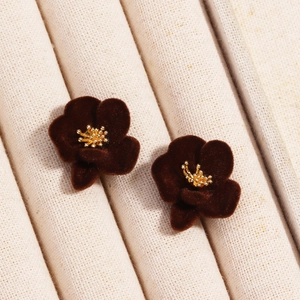 Close-up of geometric flower tassel earrings with plush texture on jewelry box