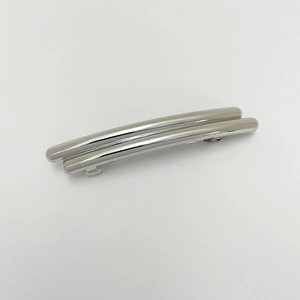 Macro detail of glossy silver long spring hair clip with irregular punk metal texture