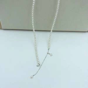 Close-up of white round pearl necklace with silver adjustable chain and spring clasp