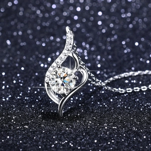 Detailed close-up of a curved silver pendant with a brilliant round-cut moissanite stone