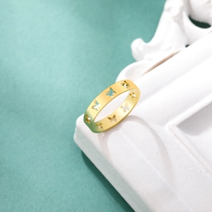 Detail of hollow butterfly patterns on a gold stainless steel band with matte finish