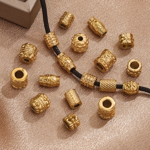 Golden stainless steel mantra beads with embossed patterns on silk background