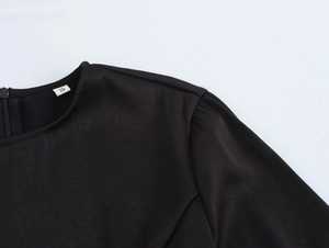 Gros plan détaillé de l'encolure ronde et du tissu texturé de cette robe noire taille S