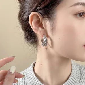 Boucles d'oreilles irrégulières en métal liquide argenté avec design fluide sur mannequin
