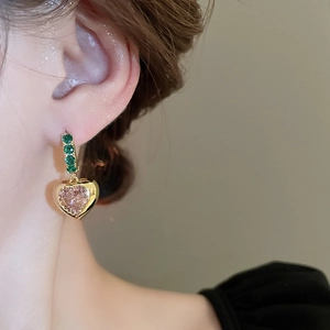 Macro view of French vintage earrings with pink heart zircon and green stones