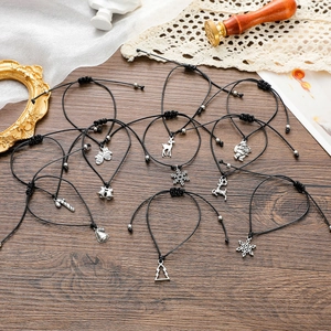 Flat lay of handmade Christmas charm bracelets with holiday pendants on a wooden table
