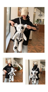 Detailed view of white teddy bear backpack with skull patterns on a model in a studio