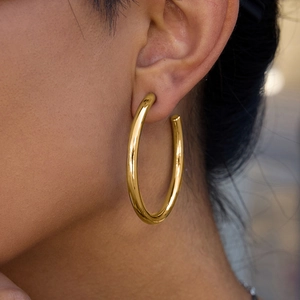 Chic gold-plated stainless steel hoop earring with a polished finish on a female model