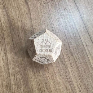 Close-up of engraved wooden date night dice featuring Italian, Chinese and Mexican food icons