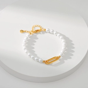 Detail of elegant handmade pearl bracelet featuring golden oval clasp and 18K gold plating