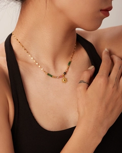 Close-up of 18K gold stainless steel necklace with sun pendant and colorful beads