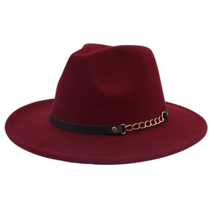 Detail of burgundy fedora hat featuring black leather band and gold metal chain accent
