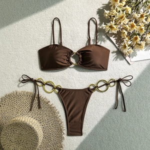 Détail d'un bikini marron foncé avec anneaux dorés et bas à nouer sur les côtés