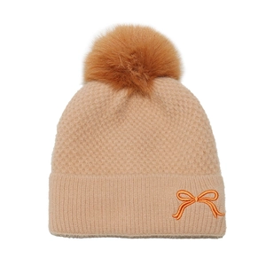 Close-up of knit texture featuring orange bow embroidery and soft pom-pom detail
