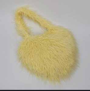 Detail of light yellow long faux fur material on this soft plush shoulder bag