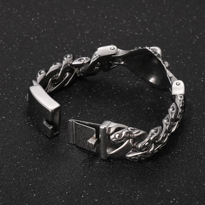 Detailed close-up of retro engraved skull charm on a vintage stainless steel Cuban chain