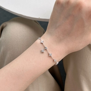 Close-up of 925 silver bracelet with delicate flower charms and sparkling round zircons