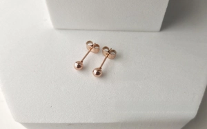 Vue macro détaillée de boucles d'oreilles rondes en or rose avec finition miroir polie