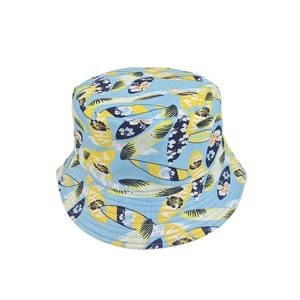 Detail of light blue bucket hat featuring yellow surfboards and tropical Aloha prints