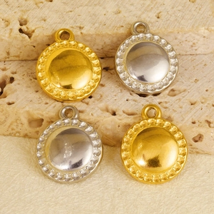 Macro view of gold and silver stainless steel round pendants with beaded edges