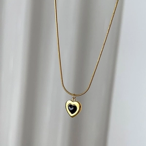 Elegant gold heart pendant necklace with black center on a sleek snake chain
