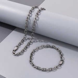 Detail of vintage silver industrial Rolo chain necklace and bracelet set on a grey display
