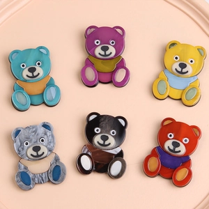 Gros plan de broches ours en acrylique coloré avec texture lisse sur un plateau