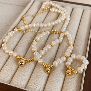 Parure élégante en perles d'eau douce avec perles dorées et pendentifs dans un plateau