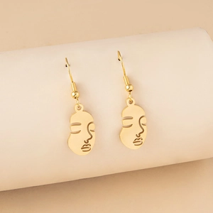 Detailed close-up of gold hollow-out abstract face earrings in retro style