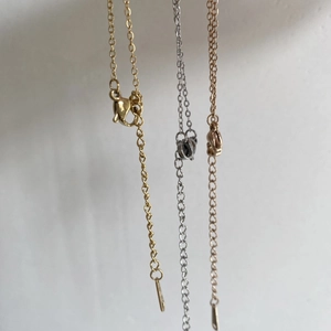 Detailed view of gold, silver and rose gold heart locket chains with lobster clasps