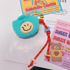 Détail de l'étui à écouteurs au crochet bleu avec smiley jaune et cordon perlé