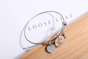 Detail of silver titanium steel bracelet with heart charms and mi mama engraving