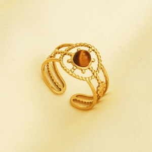 Detail of vintage gold ring with tiger eye stone on silk background, retro French style