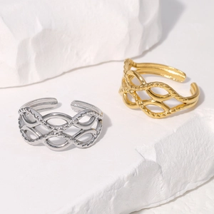 Detail of hollow woven textured open rings in gold and silver finish on white stone