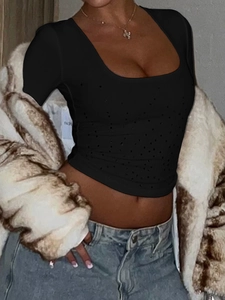 Détail d'un crop top noir en maille côtelée avec de légers ornements et col décolleté