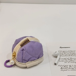 Close-up of purple quilted heart pouch with gold pearl zipper and side carabiner clip