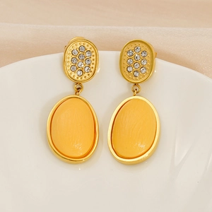 Macro view of vintage gold earrings featuring checkerboard crystals and yellow oval stones