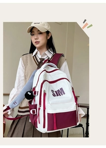 Detail of white and wine red student backpack with SJM logo and side pockets
