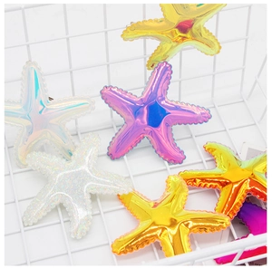 Close-up of rainbow sequin starfish hair clips with glitter finish in a metal basket